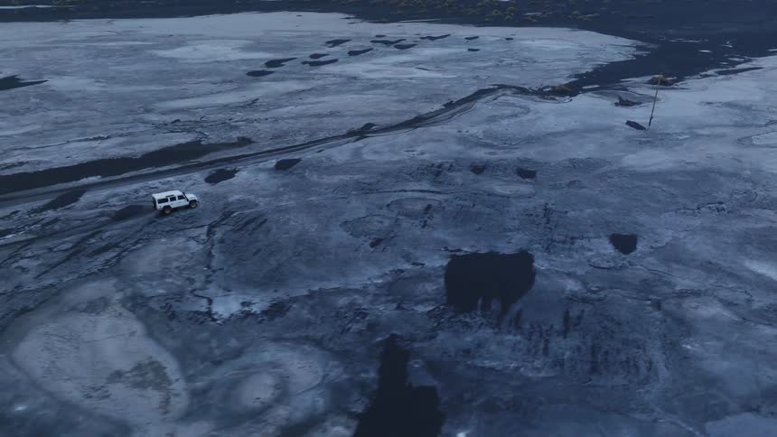 A car crossing a frozen lake during winter