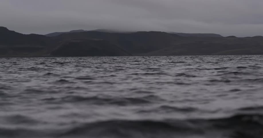 Gray skies over the ocean with land in the distance