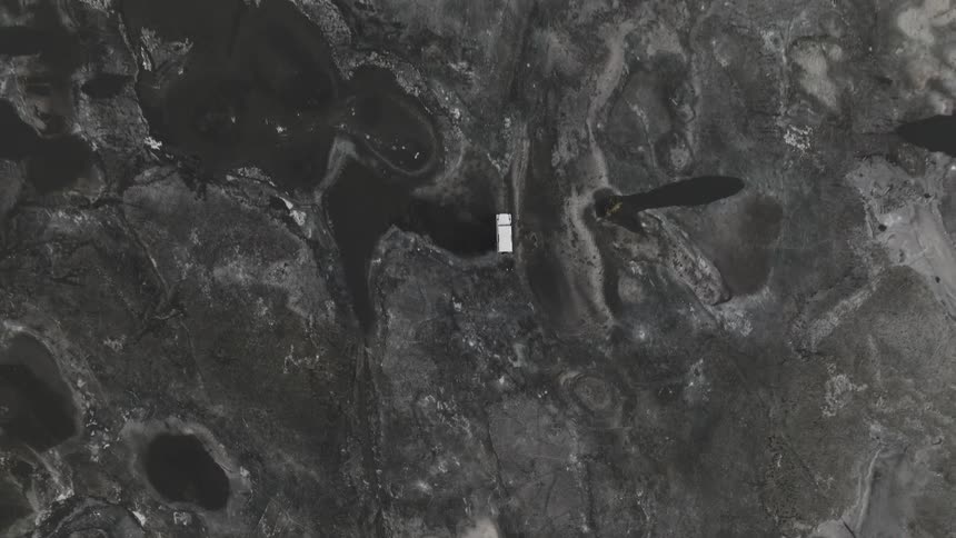 White jeep driving through a natural black soil environment