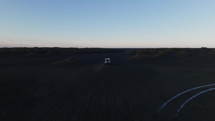 Panorama of a car traveling through natural black soil under a morning sky
