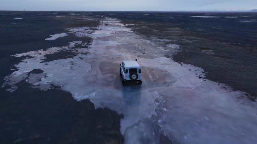 White jeep driving on frozen field with ice