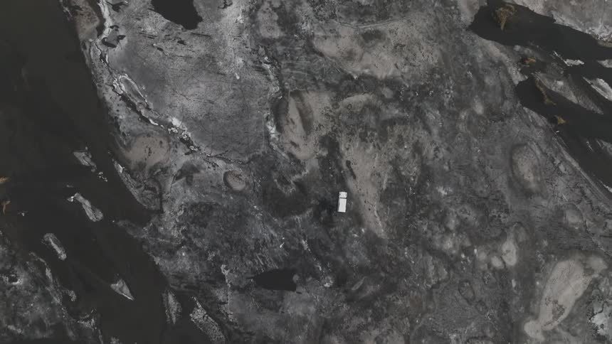 The truck is driving off road on the ice