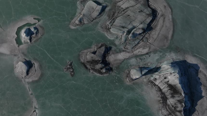 View of rocks in the middle of a frozen lake