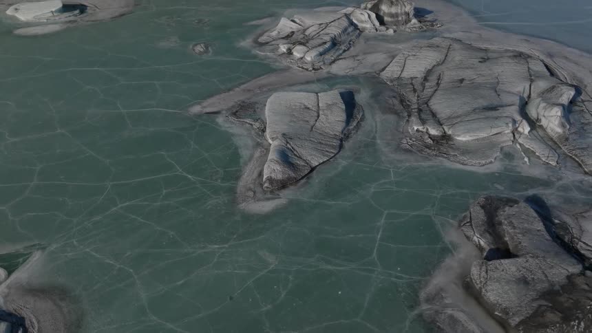 Aerial view of rocks in the middle of a frozen lake