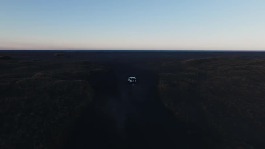 Jeep driving through a natural environment with black soil on a morning