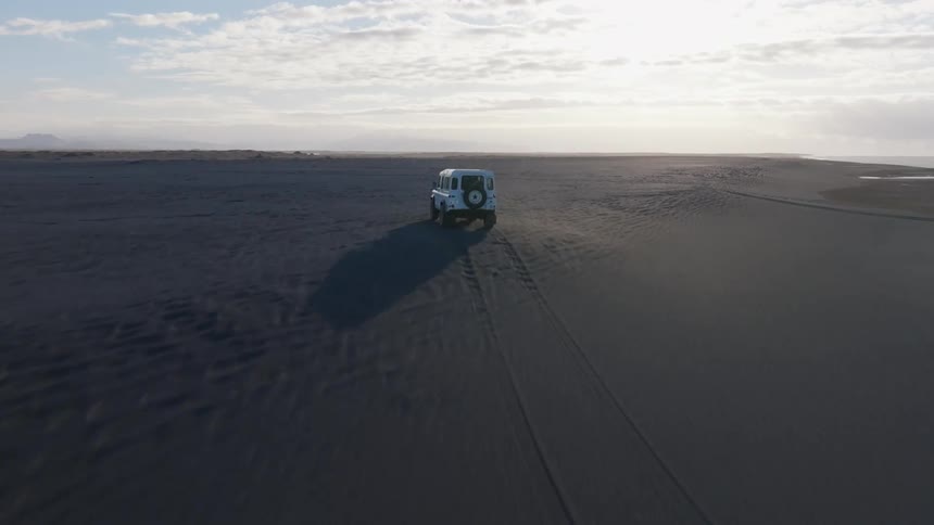 A truck is driving on the beach