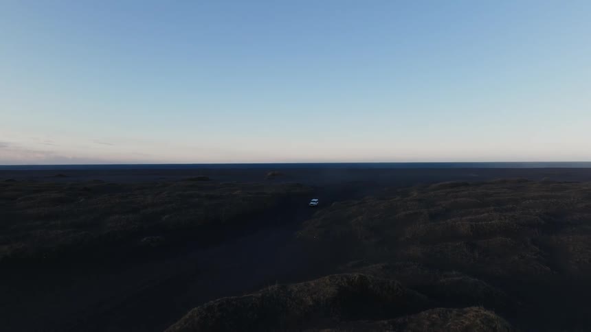 A vehicle is traveling on the flat landscape