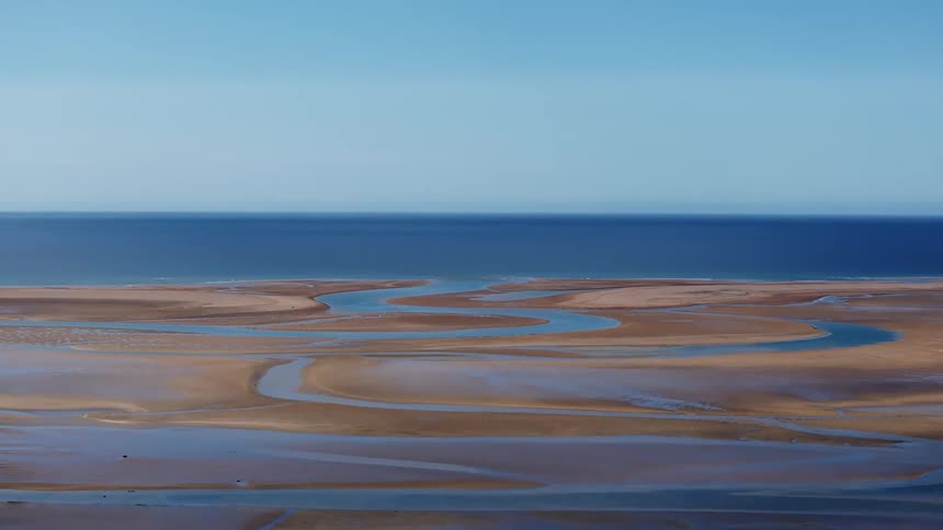 Aerial panorama of sand amidst the blue sea
