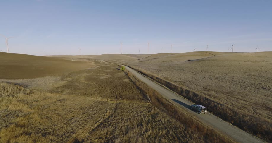 A vehicle drives past the wind farm