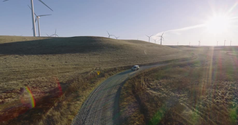 A vehicle drives past the wind farm