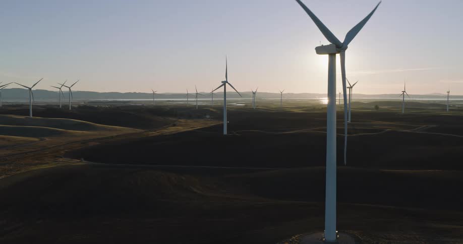 Aerial of wind turbines on wind farm at sunset