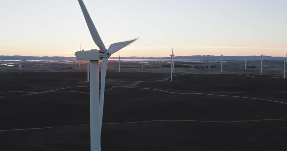 A wind farm in a small rural town during sunset