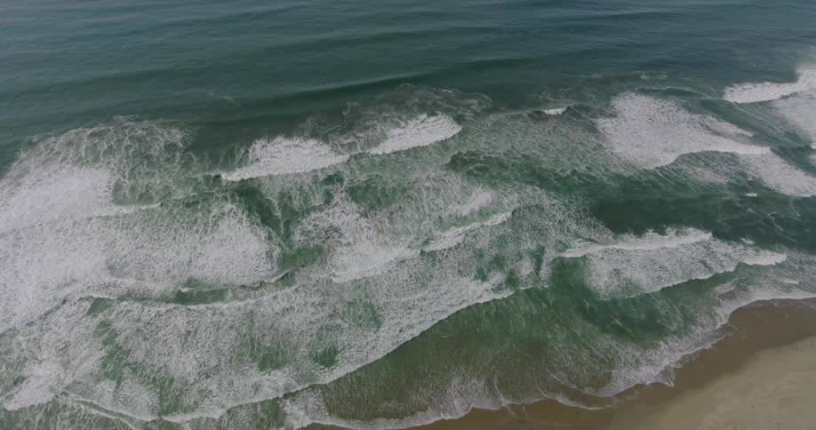 Aerial of sea waves crashing on the beach