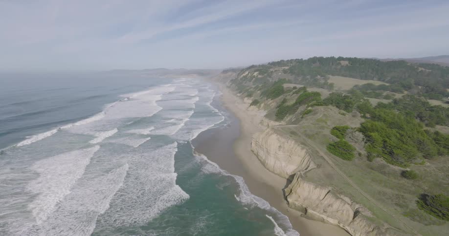 Aerial of an ocean coastline with cliffs and waves