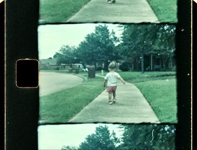 Little girl walking on the sidewalk in a residential neighborhood