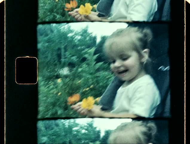 A smiling girl smelling the flowers in a garden