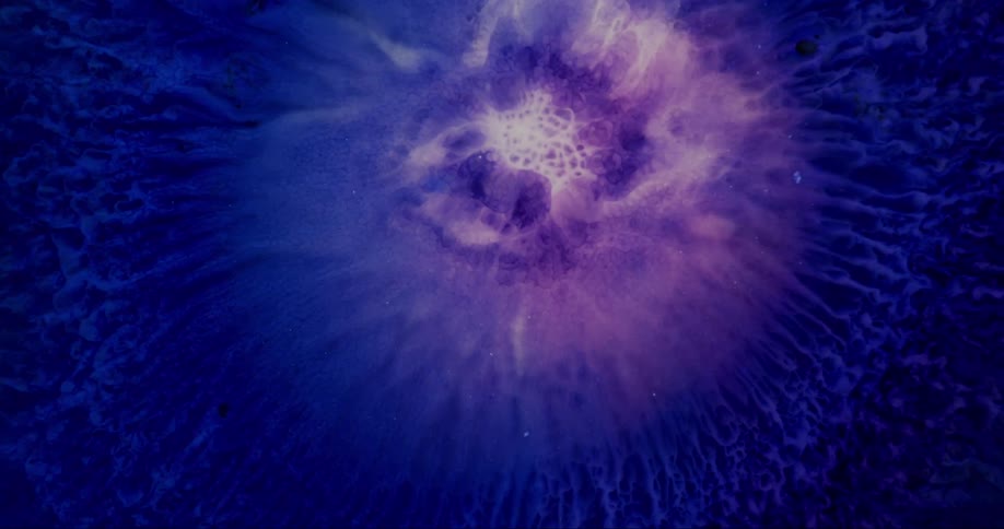 Extreme closeup of an abstract explosion of dense bluishpurple liquid