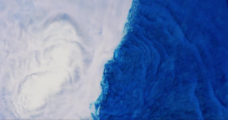 Extreme closeup of abstract white and blue fluid in collision