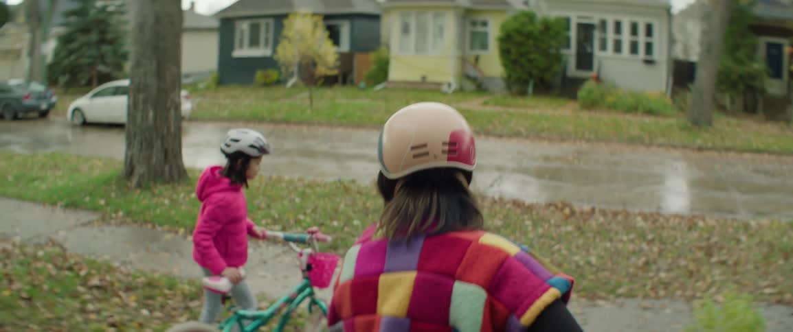 A mother and daughter take their bikes outside the house