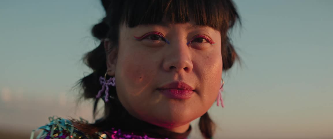 Portrait of a fashion model woman with shiny clothing in the evening sunset