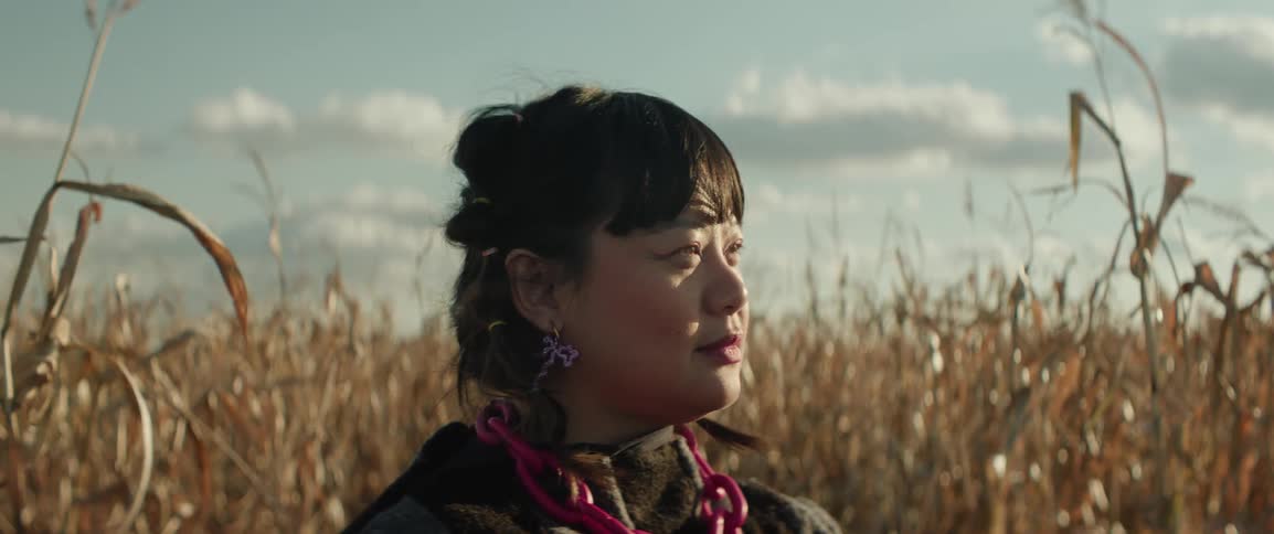 Closeup of a woman's face in a cornfield in the soft afternoon light