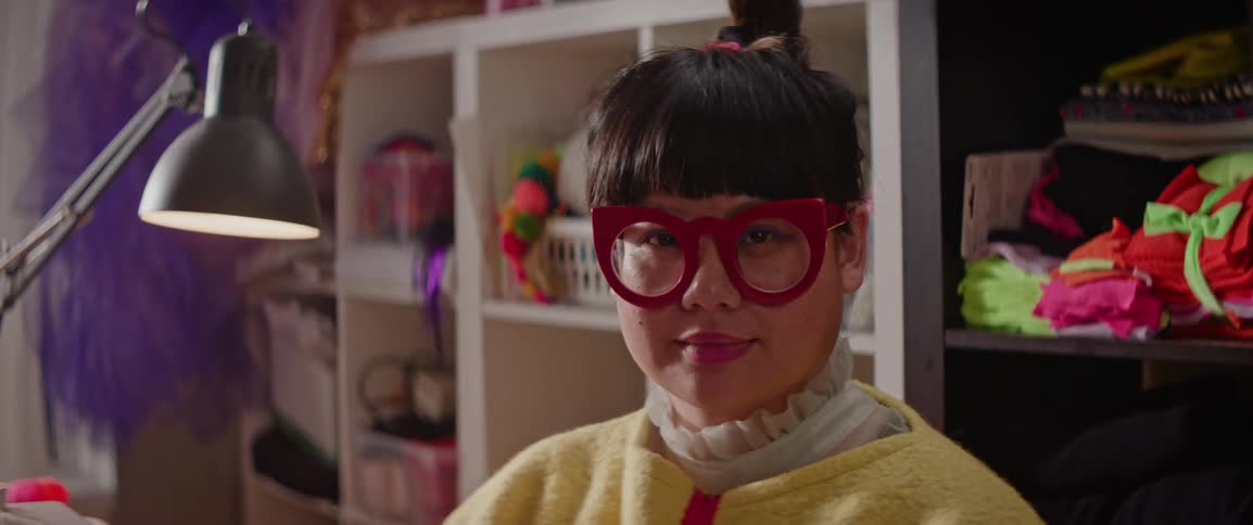 Portrait of a young asian woman with red glasses giving a slight smile