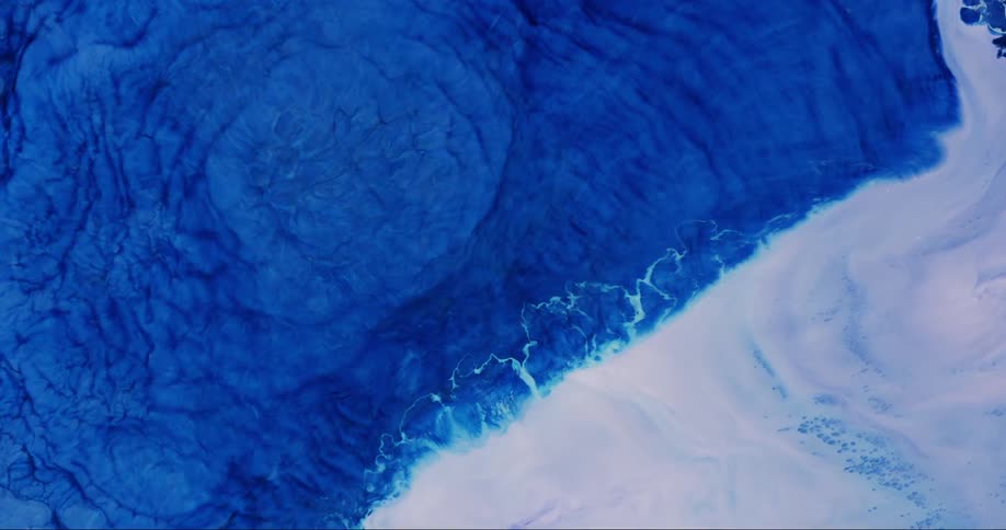 Microscopic view of abstractly boiling blue and white liquid