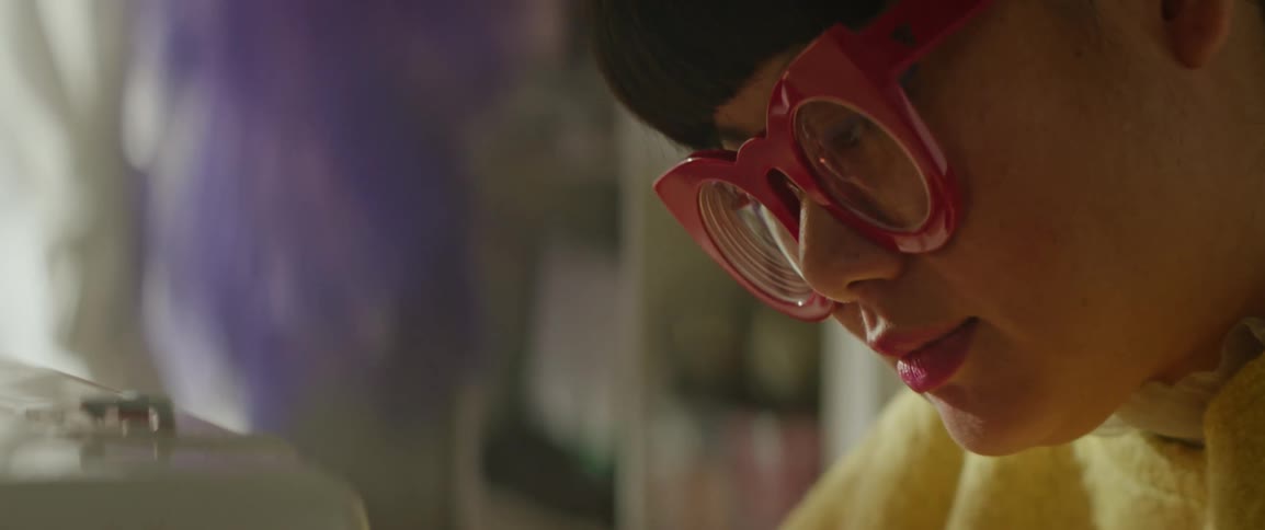 Closeup on the face of a woman wearing glasses while working