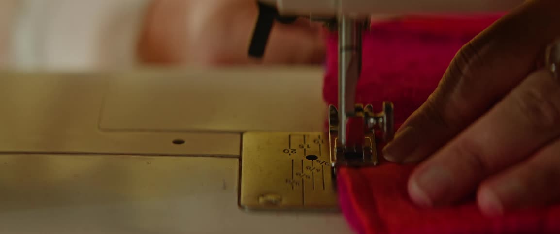 Closeup of a womans hands sewing fabric on a sewing machine