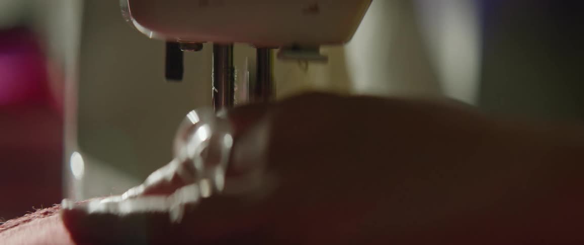 Closeup of a womans hands sewing fabric on a sewing machine