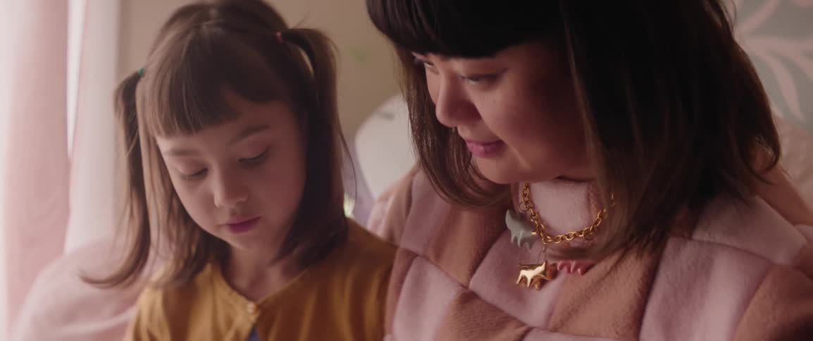 A mother helping her young daughter read a story