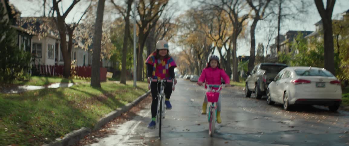 A mother and daughter ride down the road together