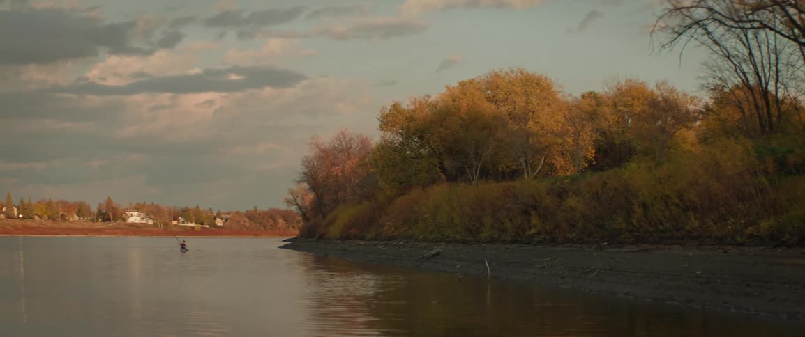 A person in a kayak paddles their way down a river