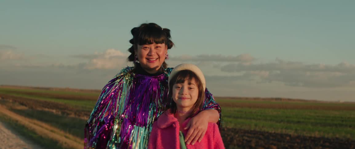 Fashion model mother next to her daughter on a rural road smiling
