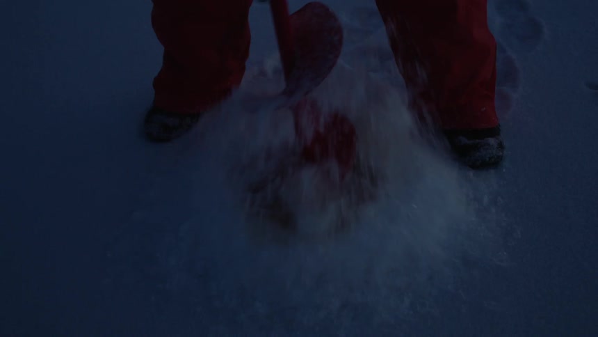 A man pulls a drill of the ice on a frozen lake