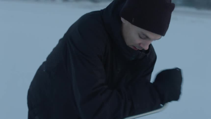 Man in a black snow cap turns an ice breaking tool quickly