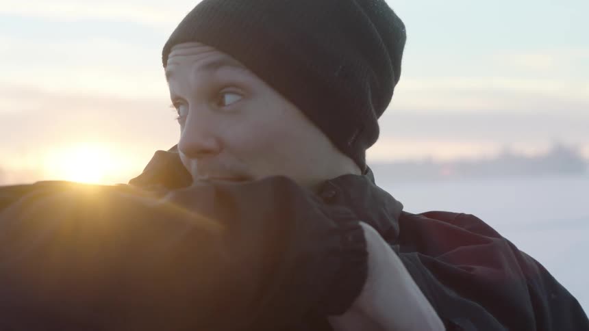 Man in a winter hat looks over his shoulder