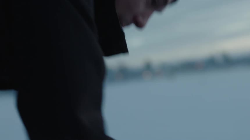 A man is working at a fishing hole in a frozen lake