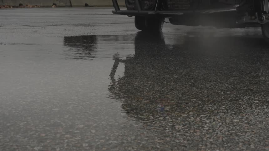 Reflection of a car sliding over a puddle in the road skid out