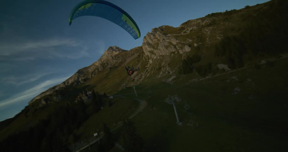 A person is paragliding over the mountains