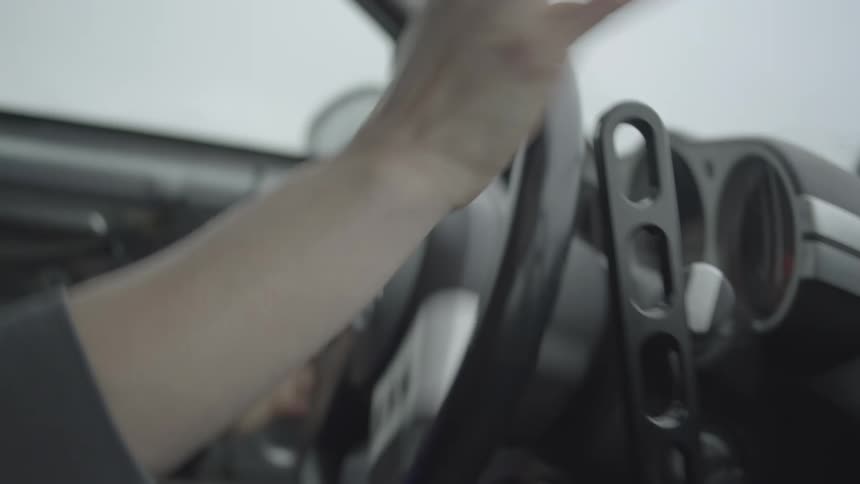 Female driver steers and shifts while drving past road signs