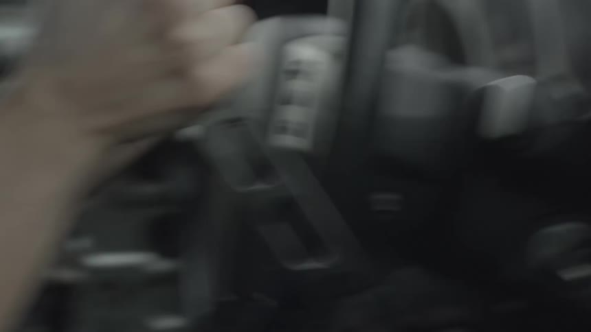 A person turning a steering wheel while driving fast on a rainy day