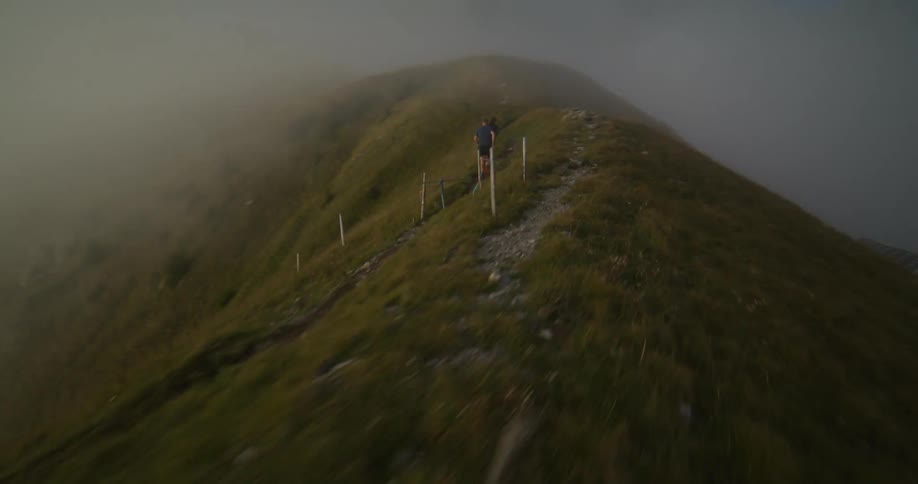 Aeral view of a couple running over the ridge of a mountain