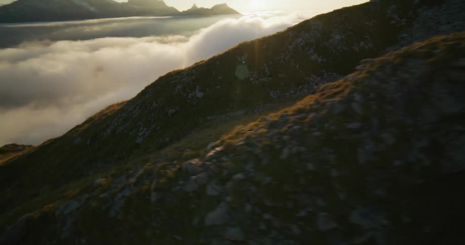Aerial view of a person hiking on the slopes of a mountain at morning