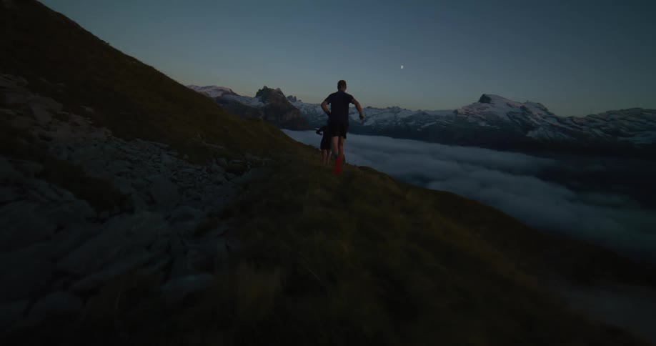 Two people running on top of the hill during sun down