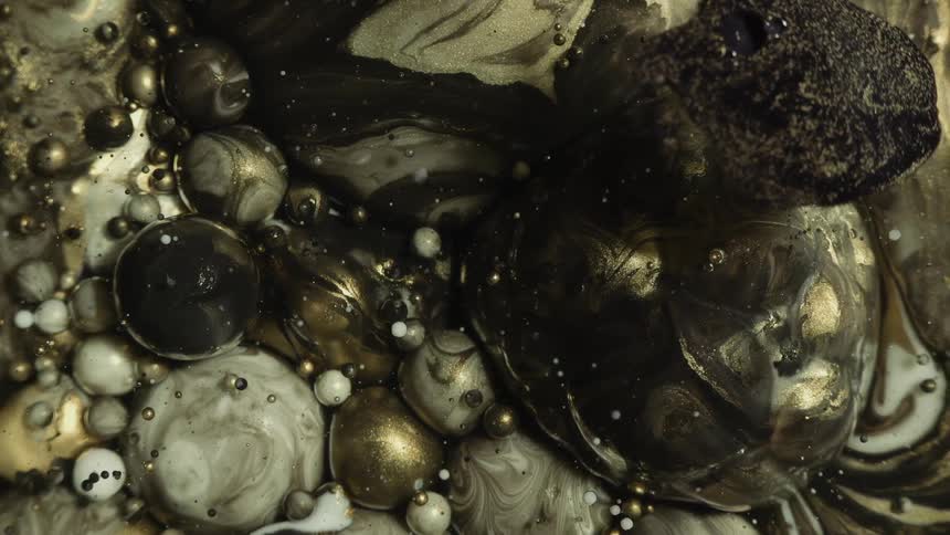 Abstract gold black and white marble oil bubbles swirl about as they burst