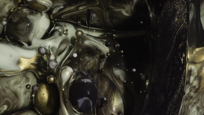 Elegant abstract swirling golden flowing colors in water