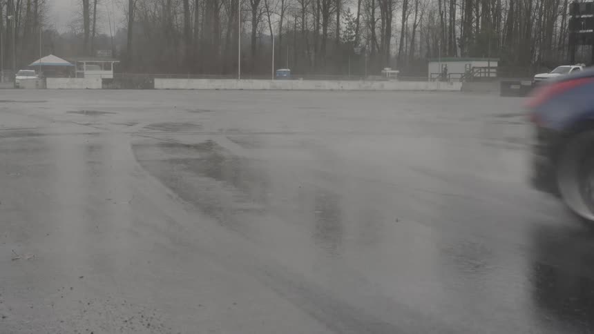 Two cars on a drifting competition over a wet track