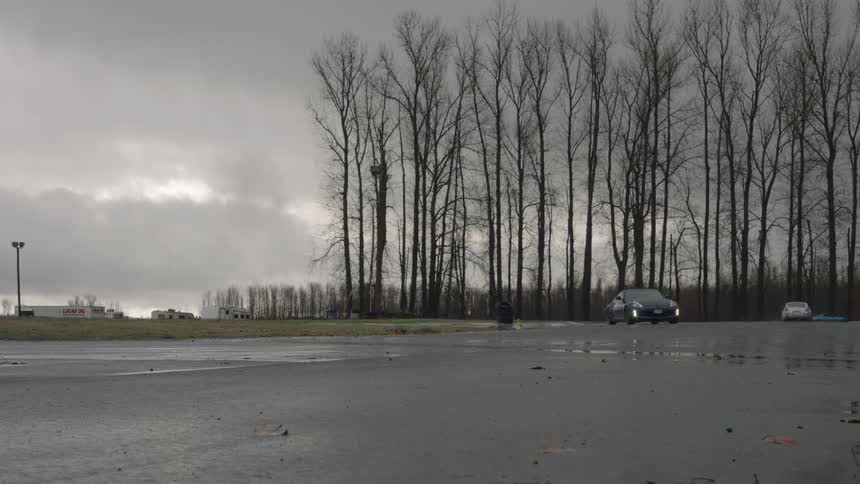 Cars are sliding on wet pavement as they race on a rainy day