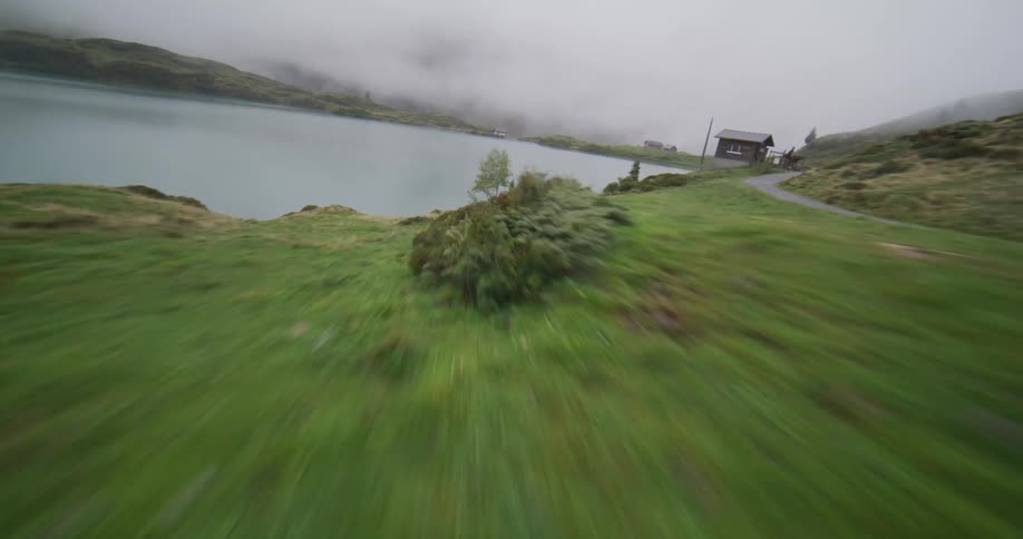 Aerial view zooming past three joggers near a river